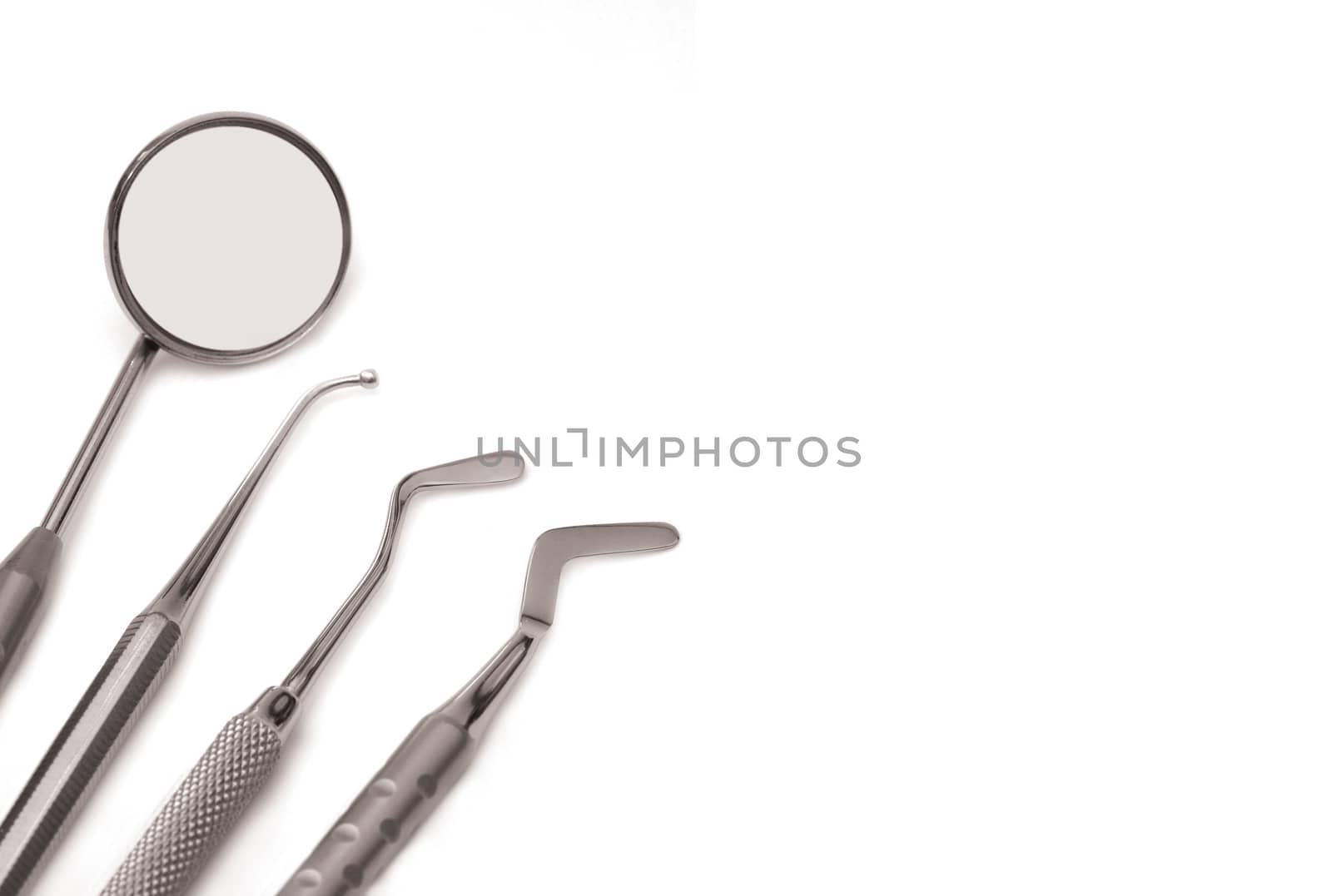 Horizontal set of chrome dental tools, viewed from the top isolated on white background