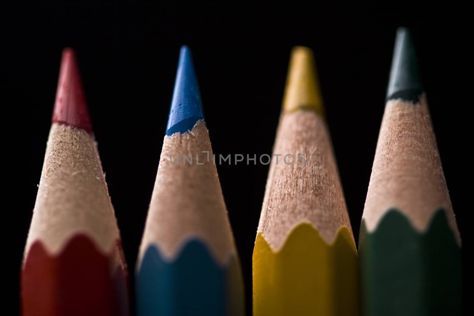 Macro of group of colored pencils with shallow depth of field on black background