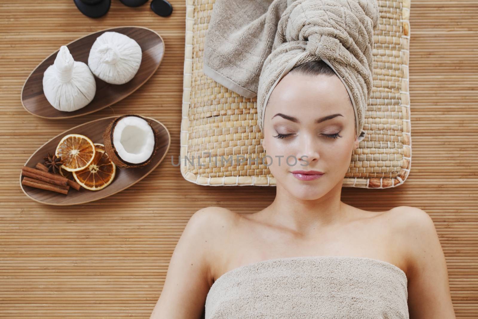 Beautiful young woman relaxing in spa salon