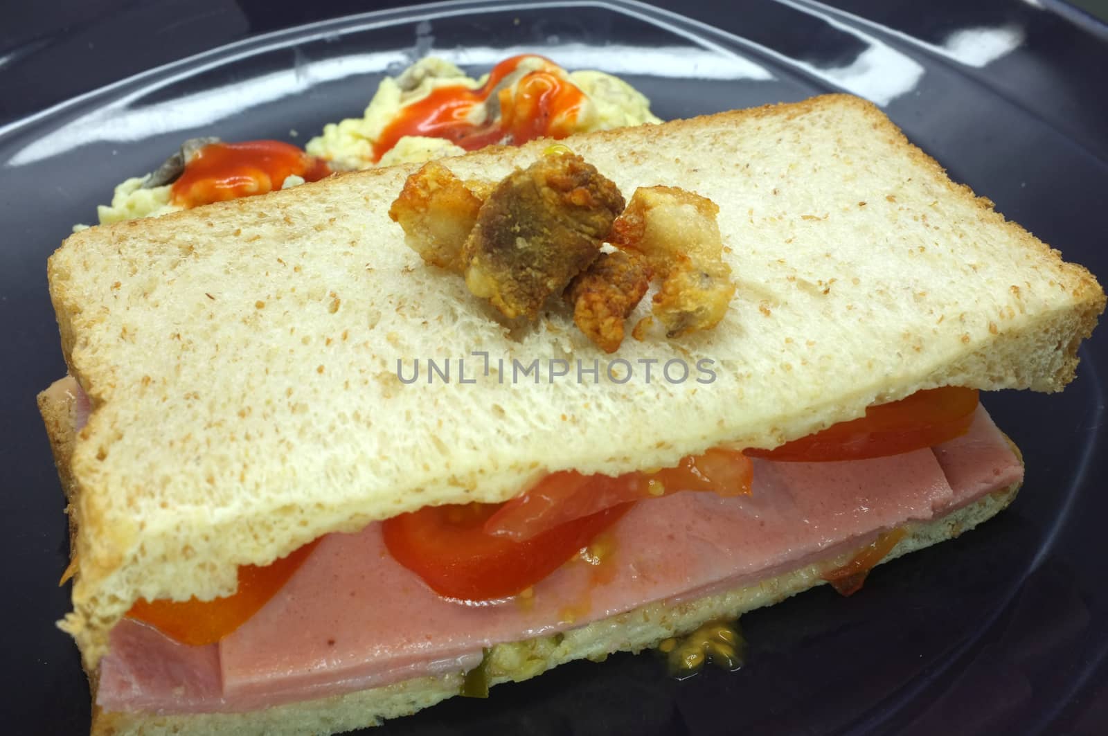 Ham and tomato sandwich with scrambled egg