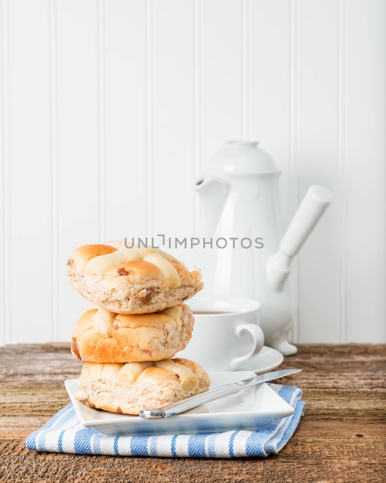 Three hot cross buns served with fresh hot tea.