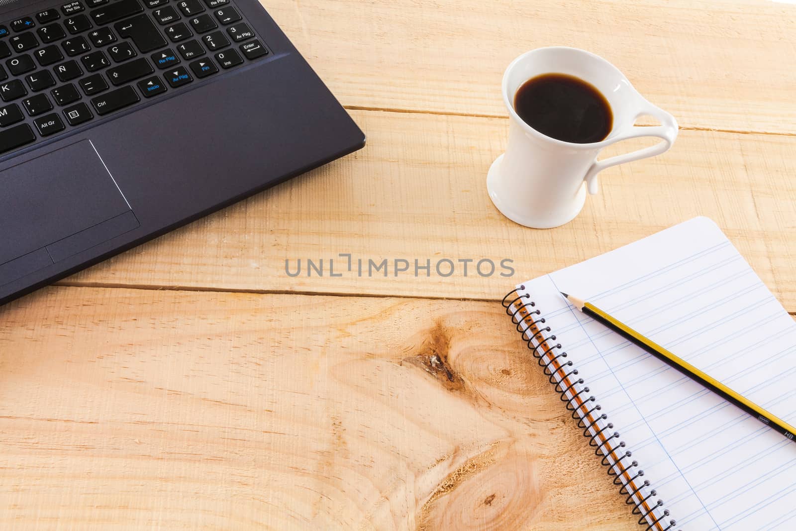 Collection of objects of an freelance worker or someone who works at home, on wooden background illuminated with natural light and photographed from above