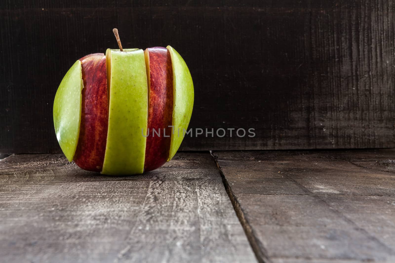 The image shows apple surrounded by a measuring tape referring to diet and health concept on wooden background