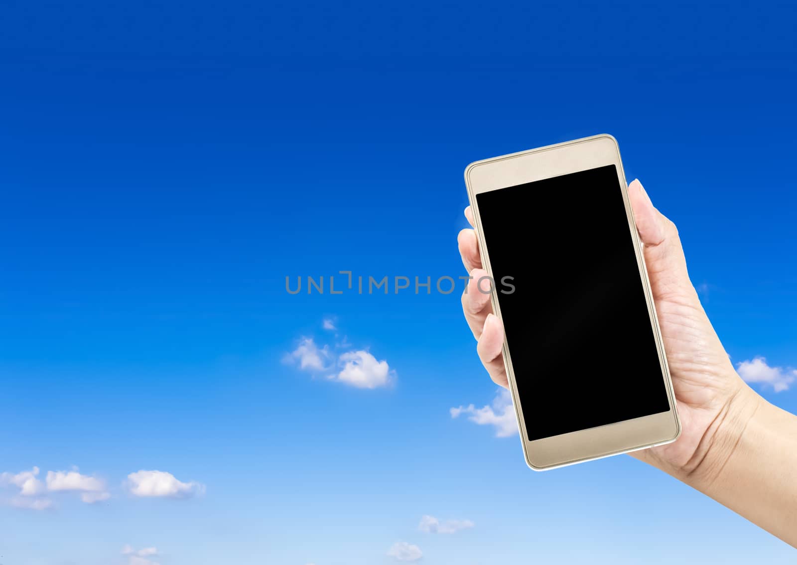 Mobile phone in hand on blue sky background