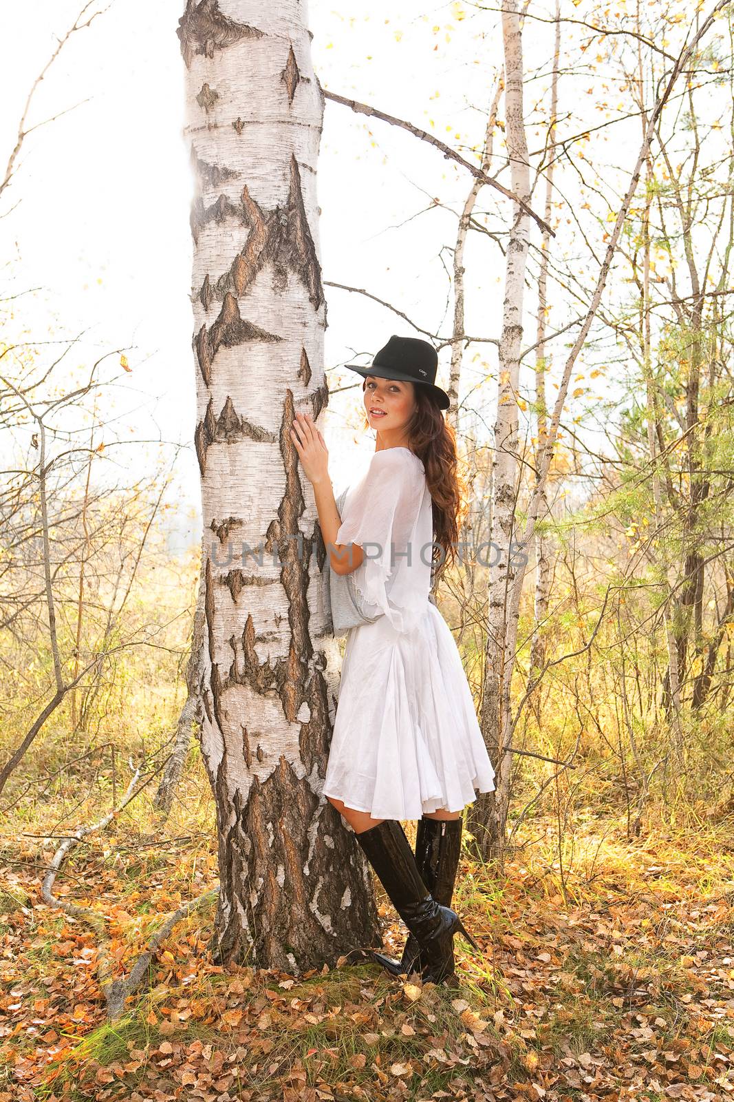 Young beautiful woman in fashionable clothing in the forest