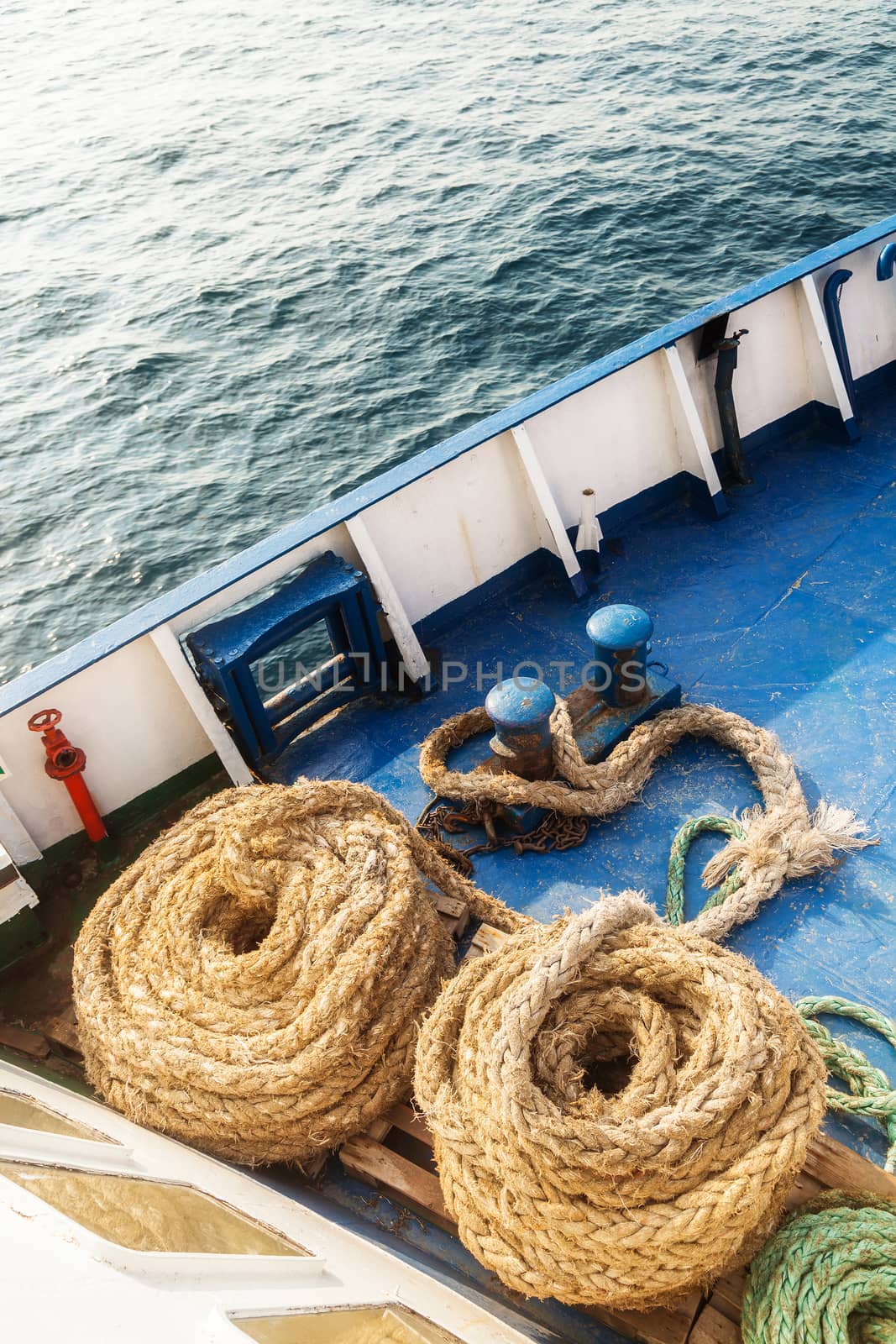 Two old fleecy ropes curtailed into a spiral on the deck of the vessel