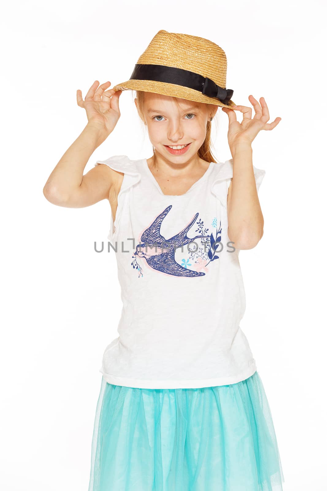 Little girl posing for the camera in a brown hat