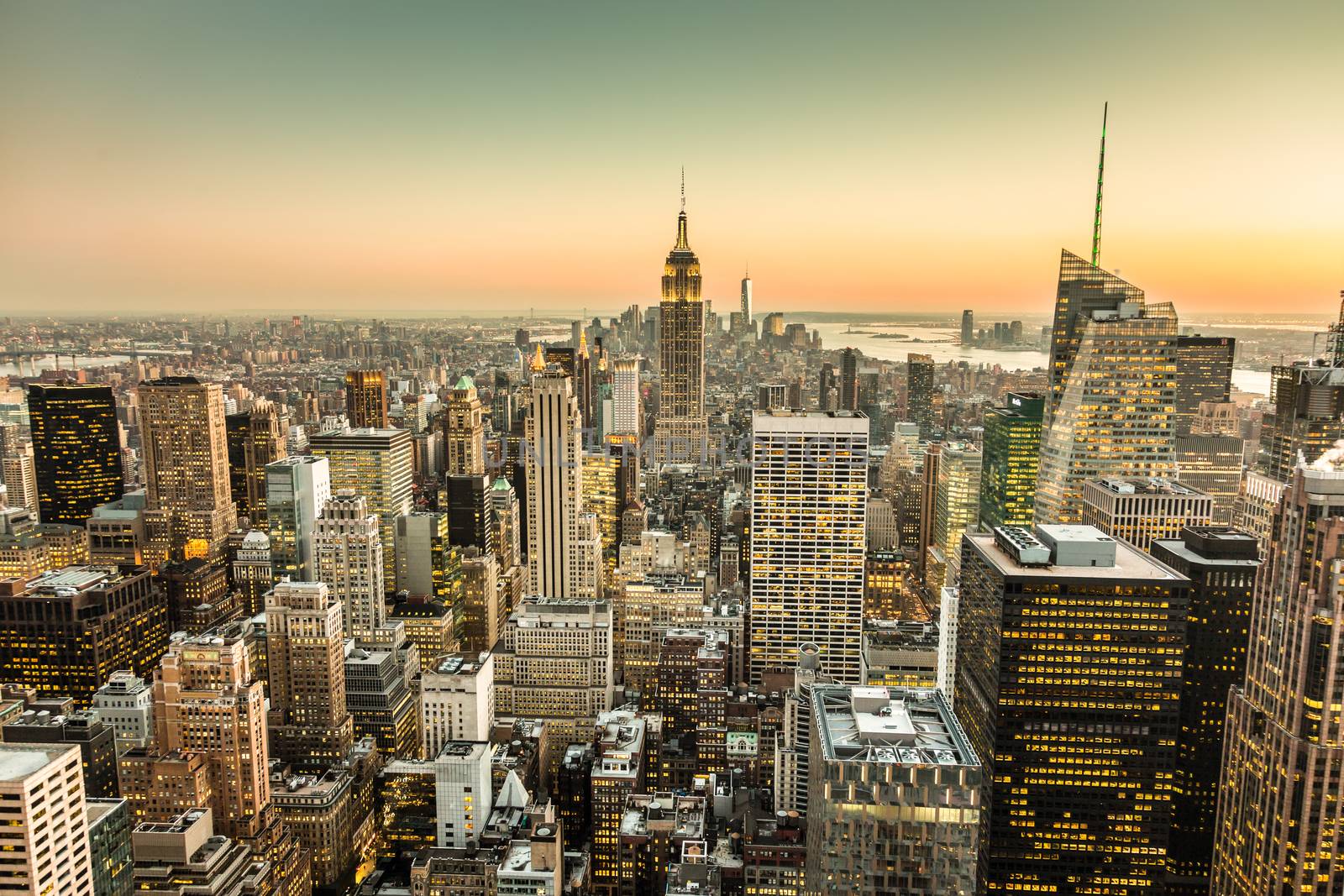 New York City. Manhattan downtown skyline with illuminated Empire State Building and skyscrapers at dusk.