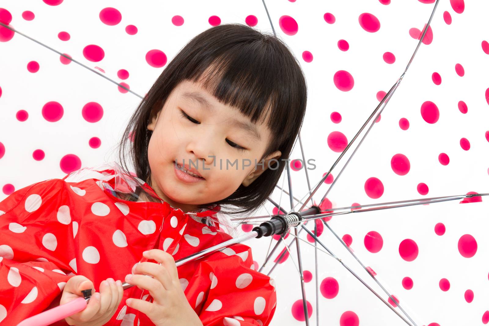 Chinese Little Girl Holding umbrella with raincoat in plain white isolated background.