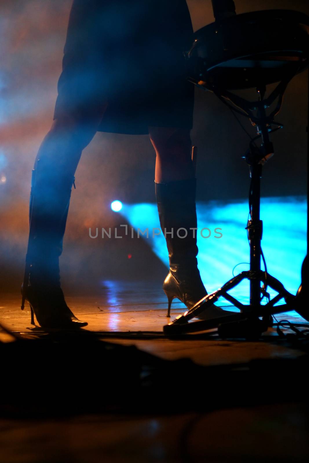 Silhouette of an attractive female drummer on stage