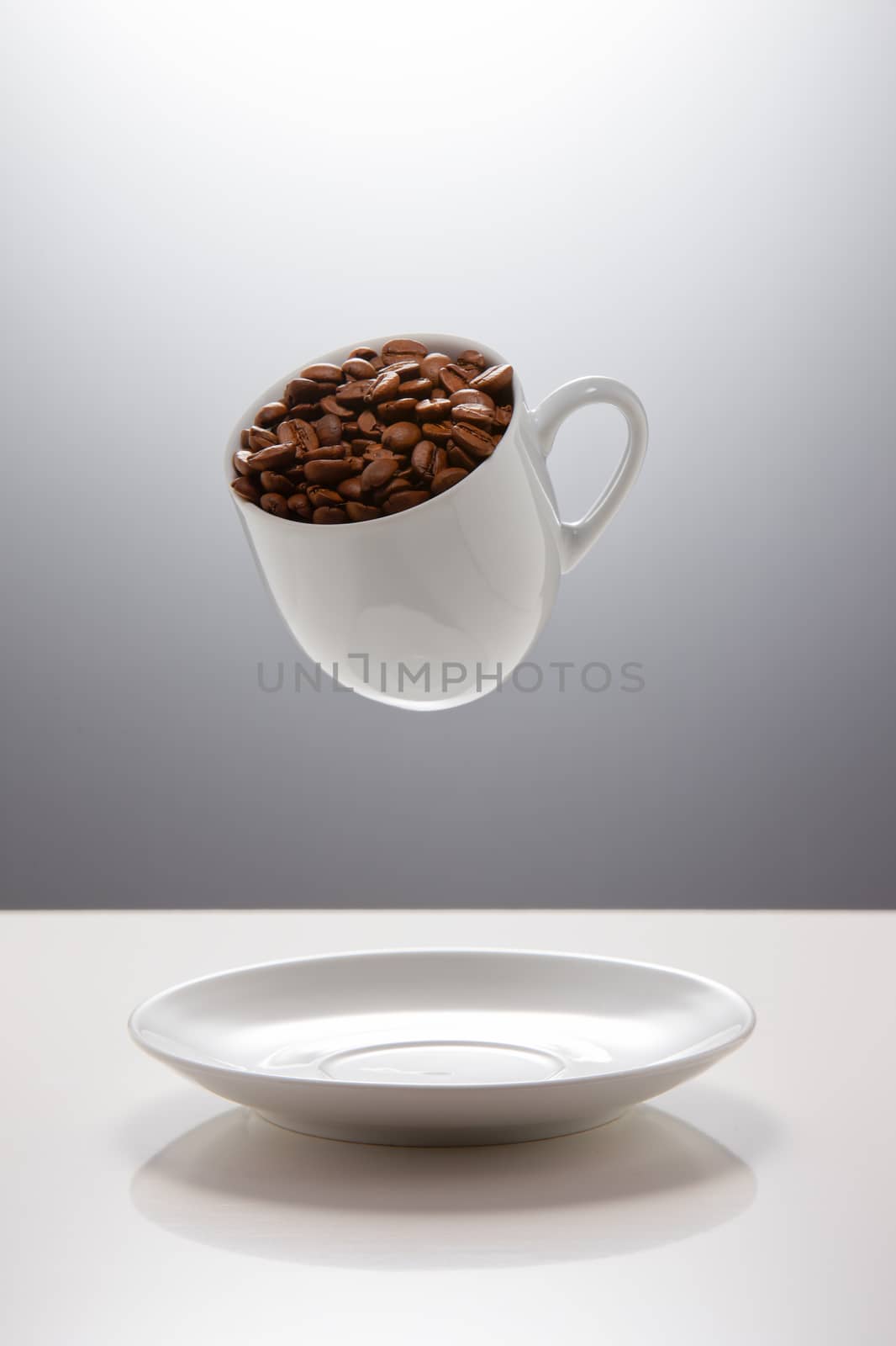 Cup for coffee with beans flying over the table