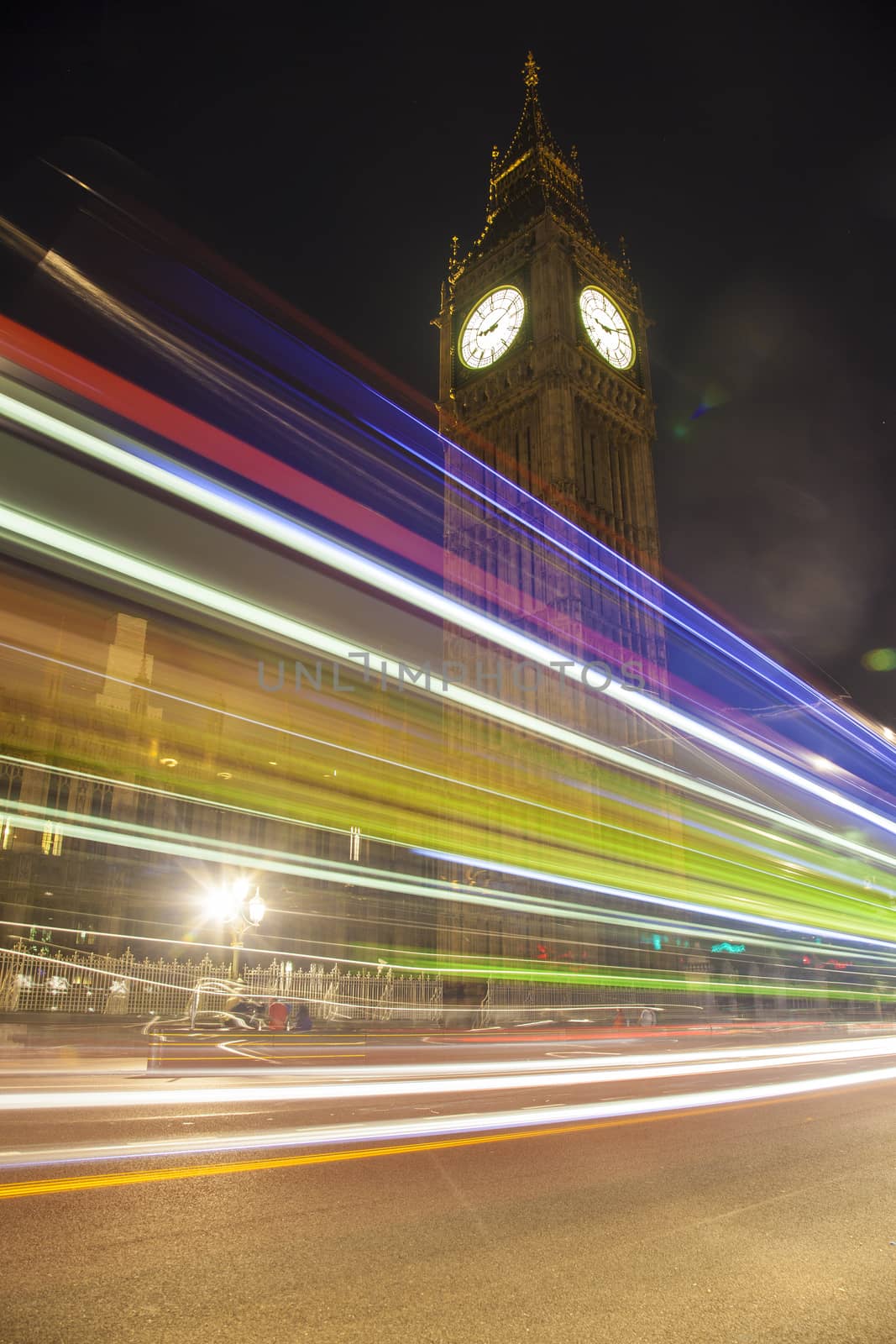 Night view on Big Ben and light trail of a bus in front.