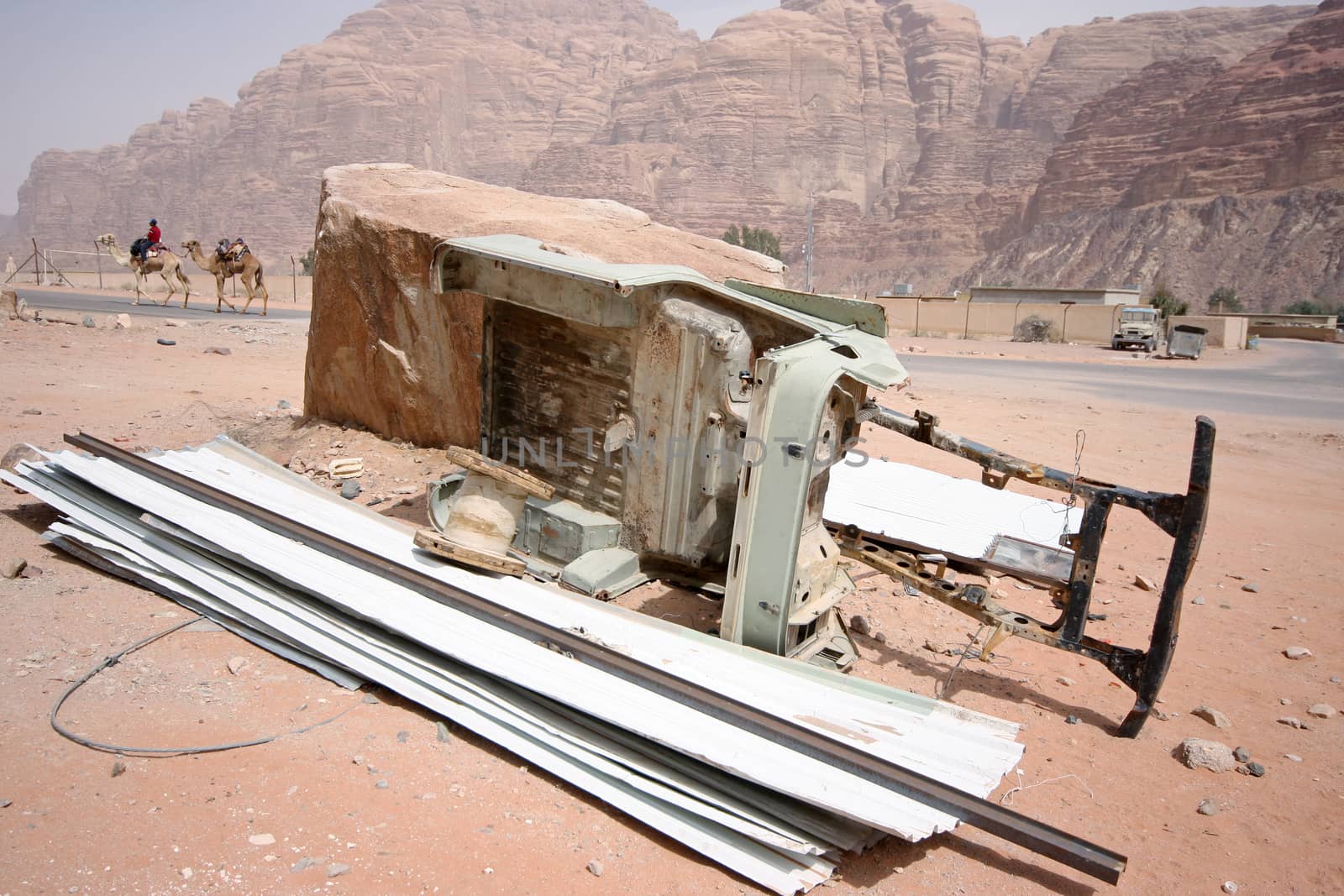 Chassis of a jeep and camels in the back - scene from a desert in Jordan