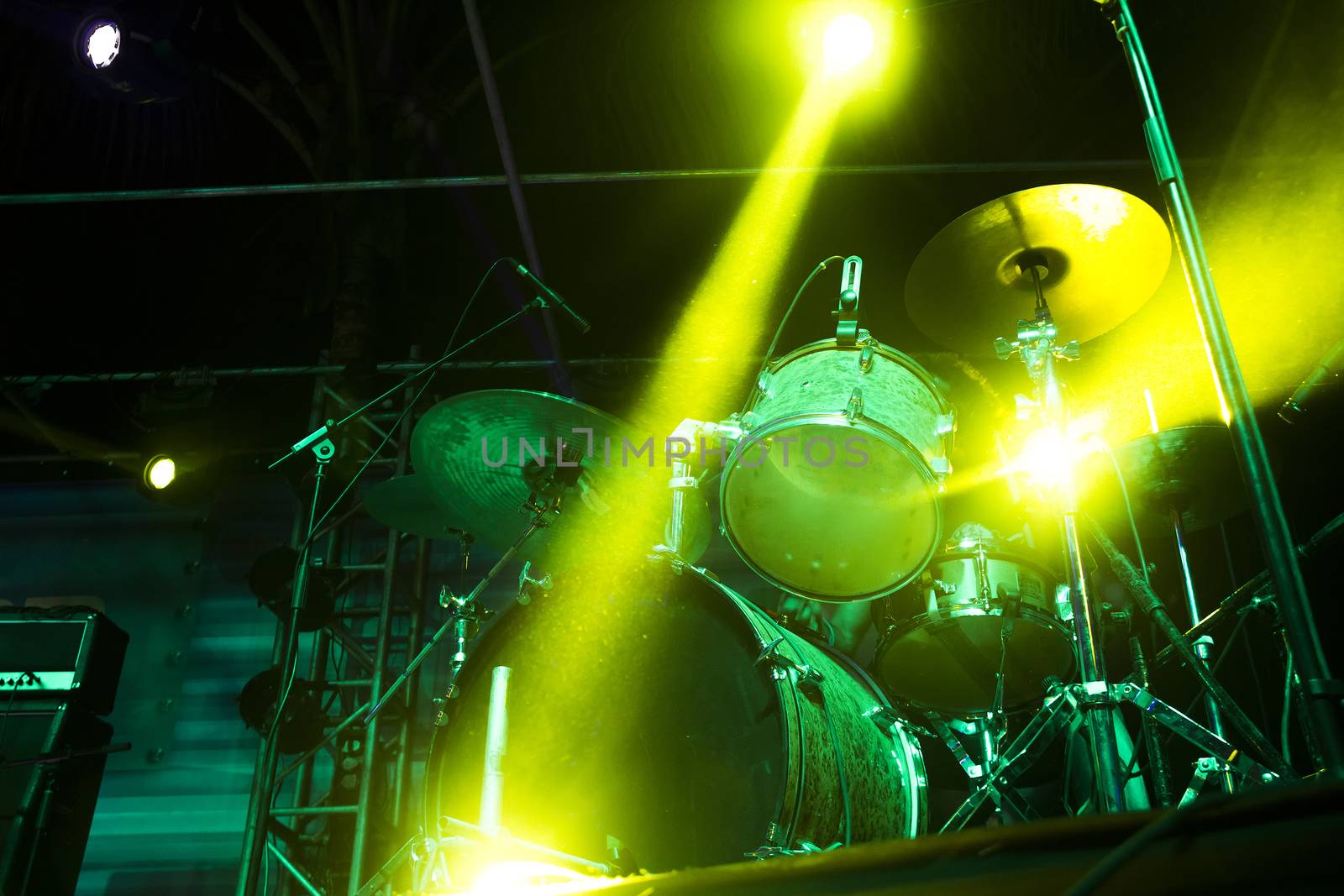 Drumset on an empty stage light with strong backlight