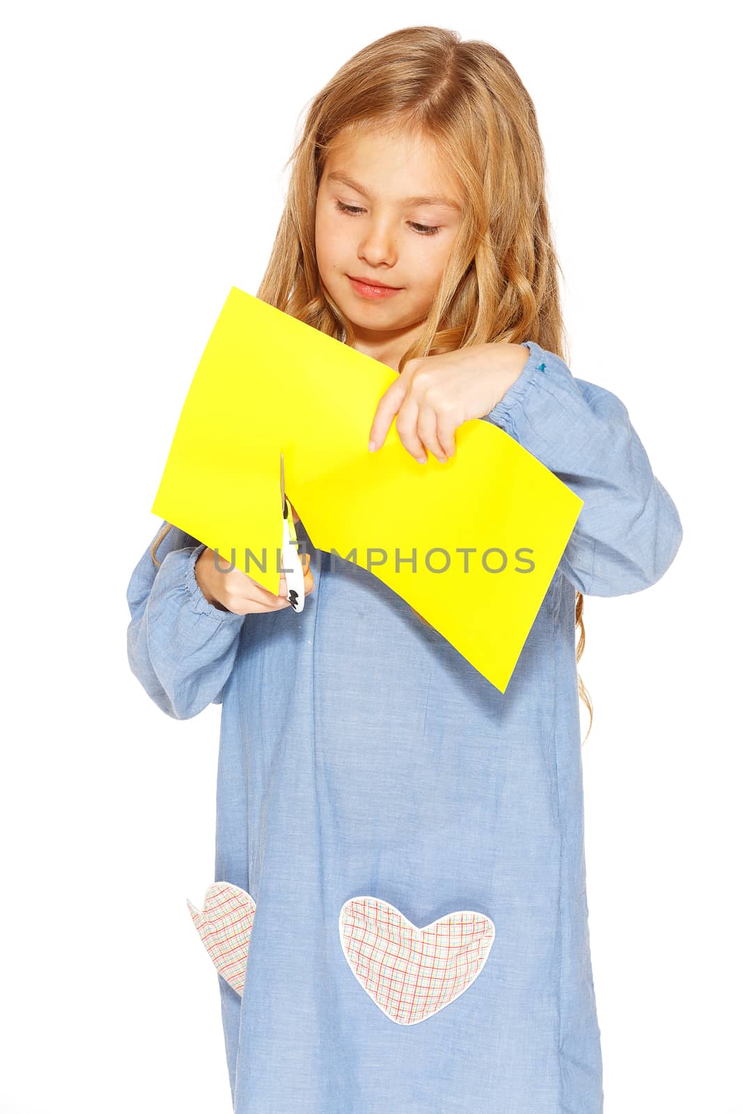 Little cute girl making handmade yellow hearts