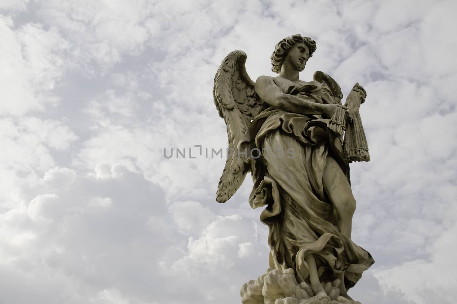 Marble statue of angel in front of heavenly clouds in Vatican