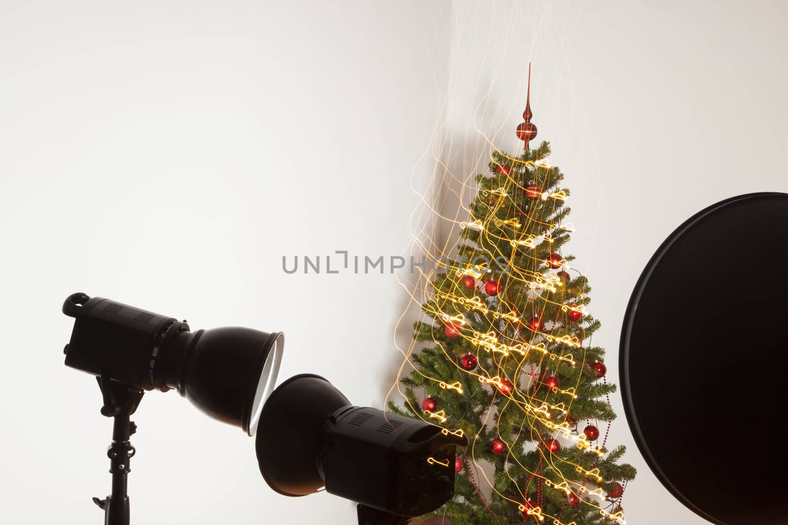 Decorated Christmas tree with studio equipment in front view.