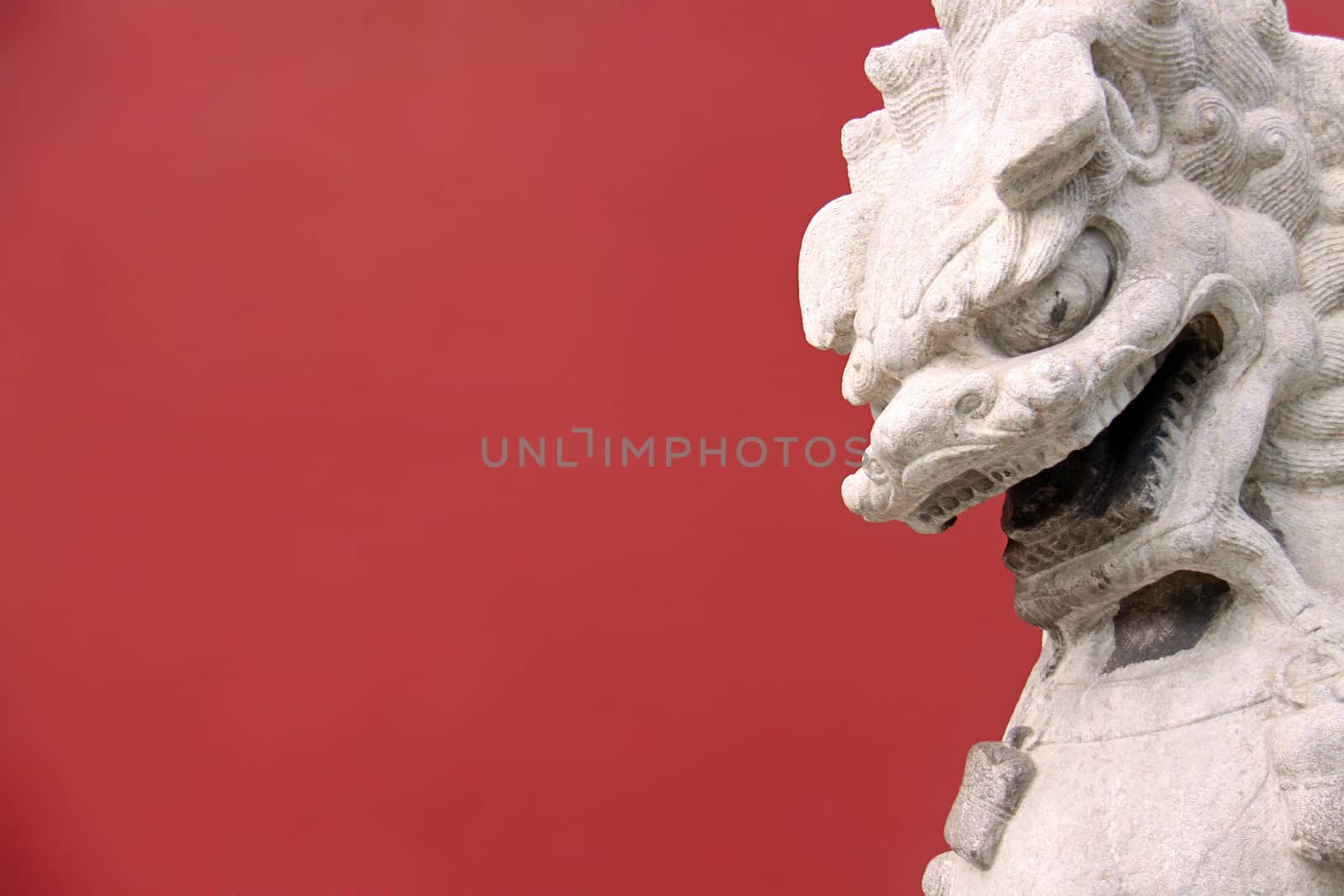 Lion on red background taken infront of an entrance on a garden of the Forbidden City in Beijing, China