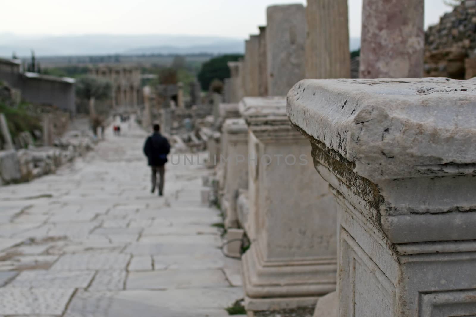 A man walking by the ruins of ancient city in Efes