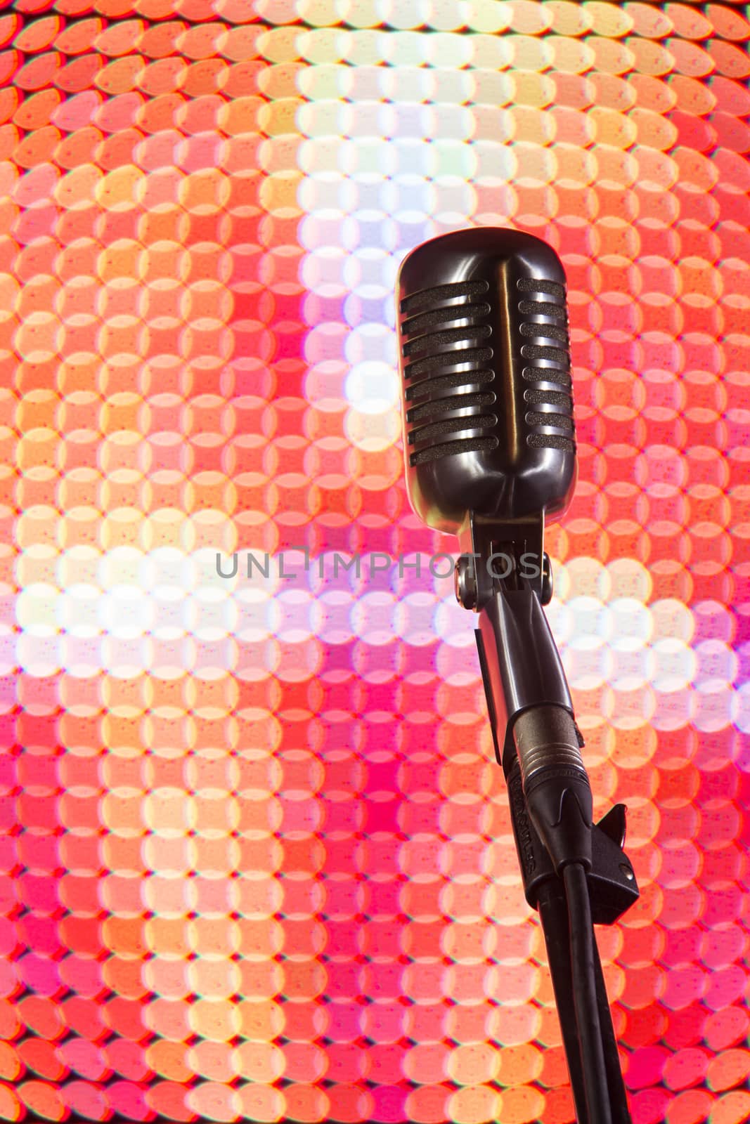 Shure 55SH microphone in front of coloured lighting wall.