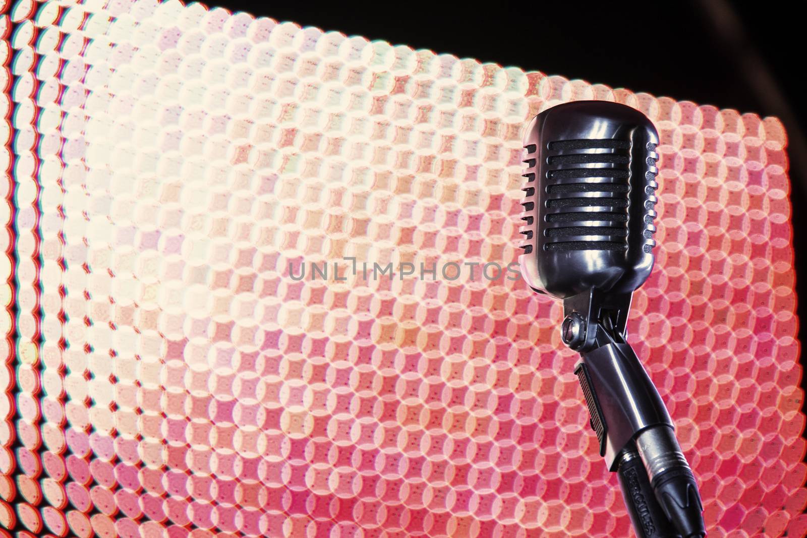 Shure 55SH microphone in front of coloured lighting wall.