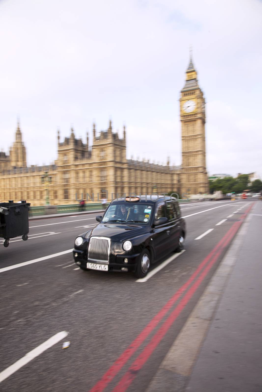 Typical London taxi in front of a Big Ben. Other traffic in the background.