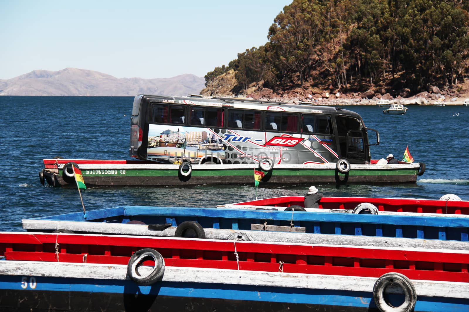 Tiquina, Bolivia - September 28, 2010: Bus crossing lake Titicaca on a raft while passangers take the boat