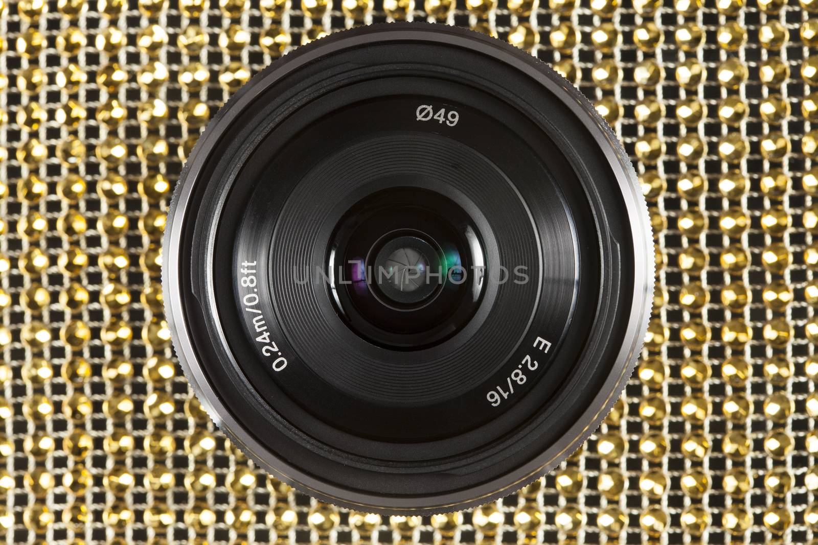 Sony SEL 16F28 Interchangeable Alpha E-mount 16mm f2.8 lens on golden colour pattern.