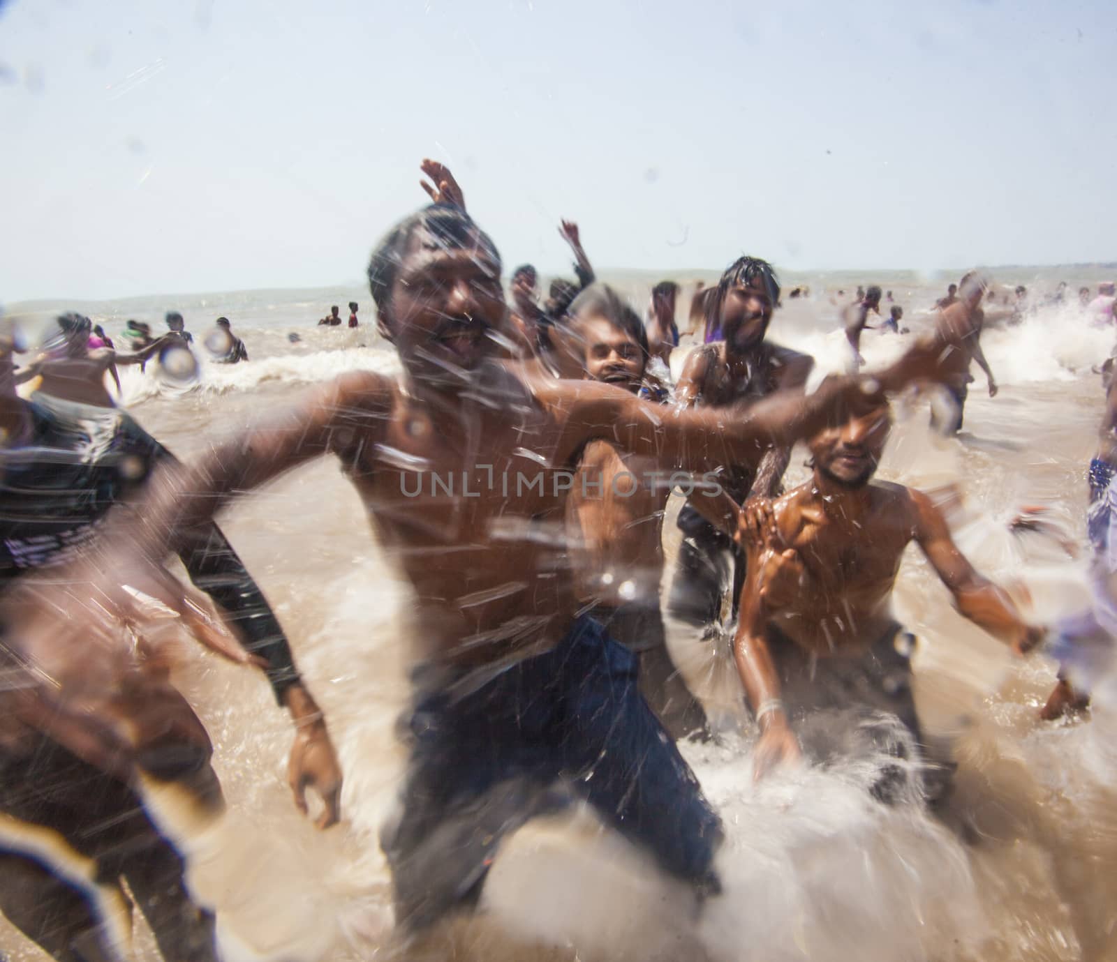 Indian men celebrating Holi on Juhu Beach in Mumbai.