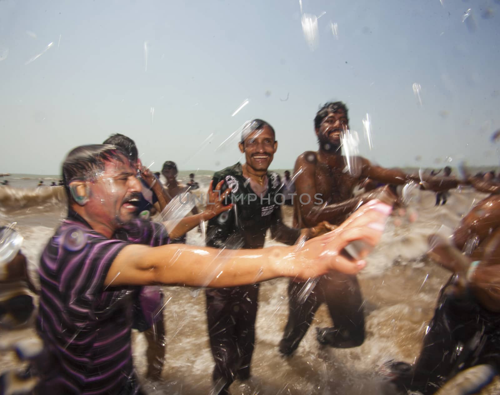 Indian men celebrating Holi on Juhu Beach in Mumbai.