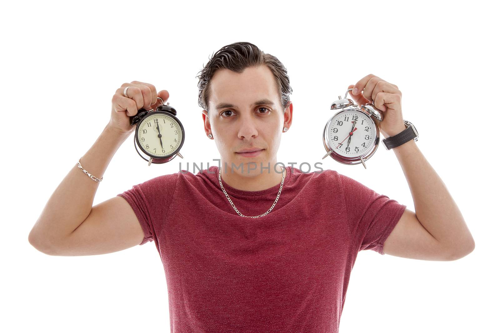 Young man is holding two alarm clocks at 6 o'clock over white background