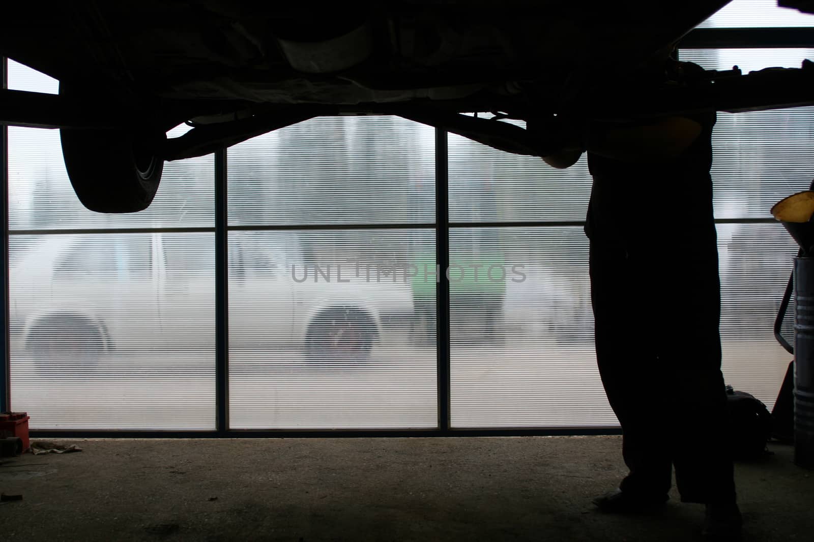 Silhouette of a mechanic fixing car in his workshop