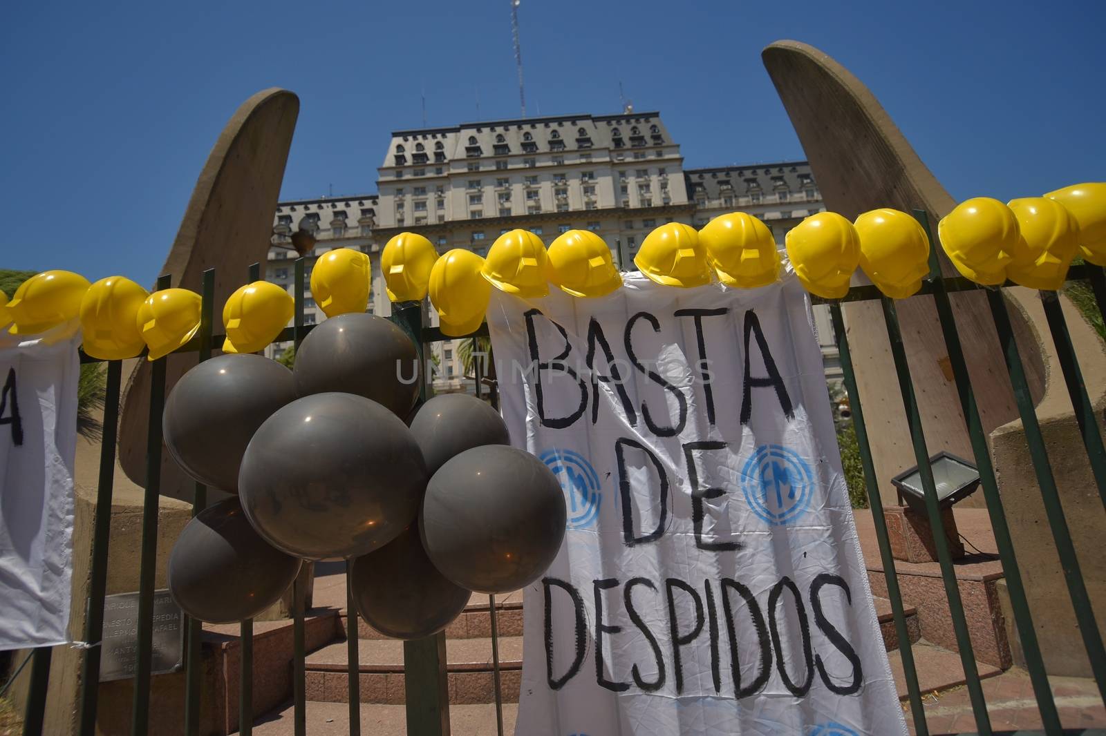 ARGENTINA, Buenos Aires: Hard hats rest on a fence in Buenos Aires, on February 1, 2016, in a show of support with 140 workers who were fired. The sign reads 'No More Layoffs'