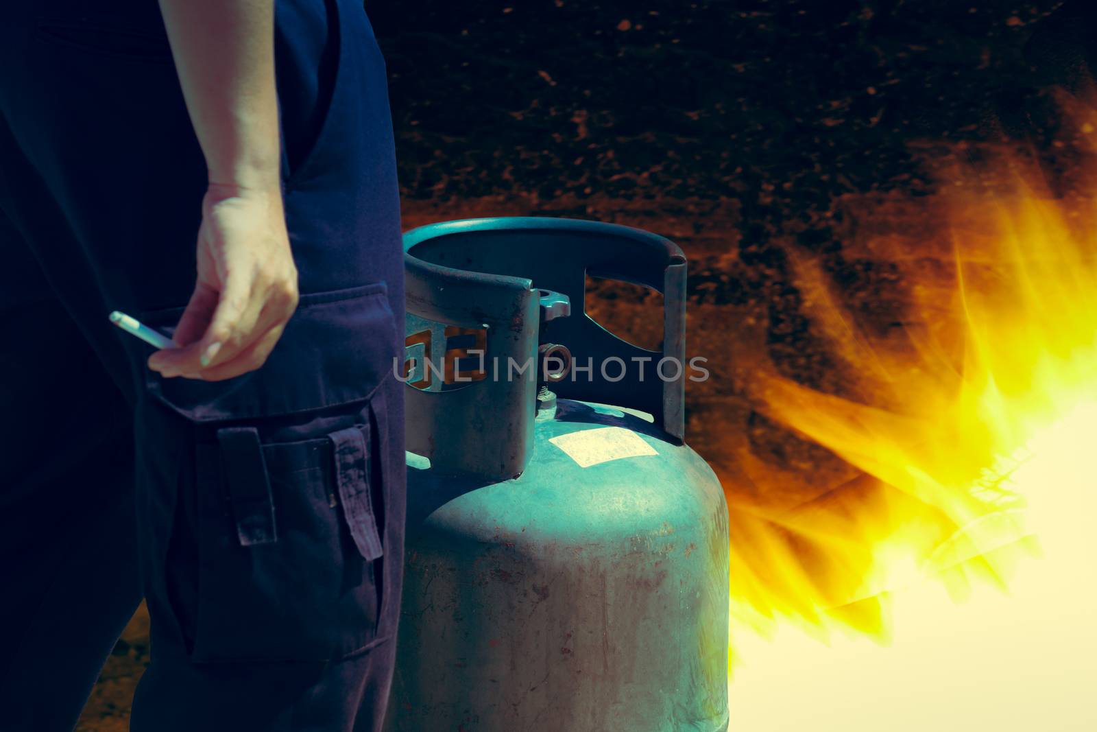 Cigarette in hand near gas tank cylinder can ignition of flammable, safety concept