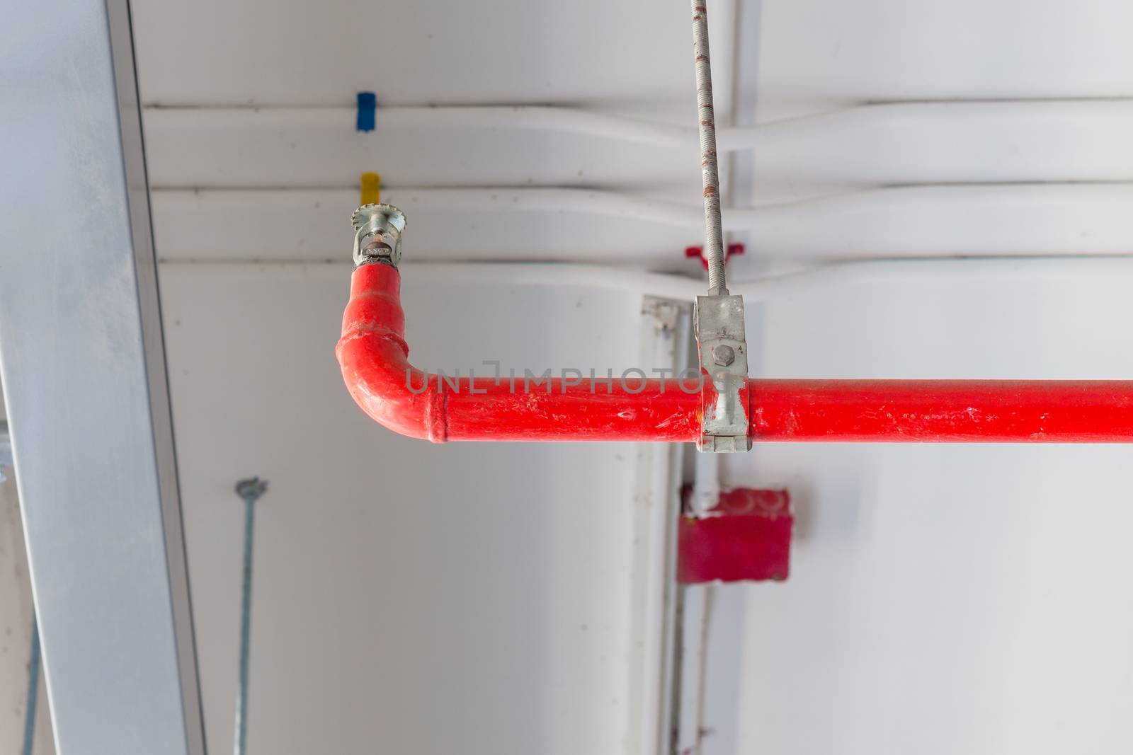 Fire sprinkler and red pipe installed on ceiling for safety conc by FrameAngel