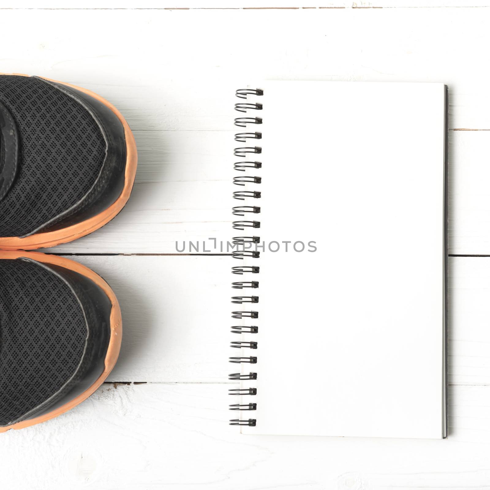 running shoes and notepad on white wood table