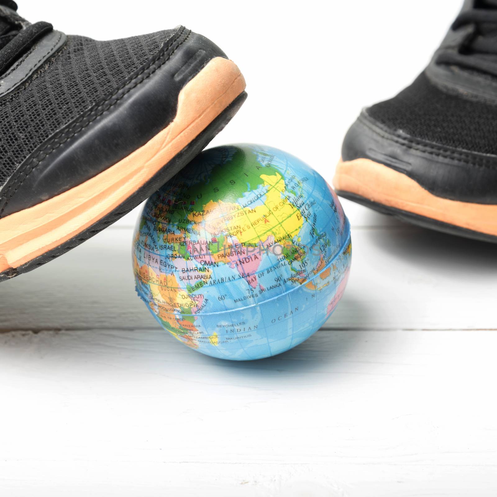 running shoes and earth ball on white wood table concept world healthy