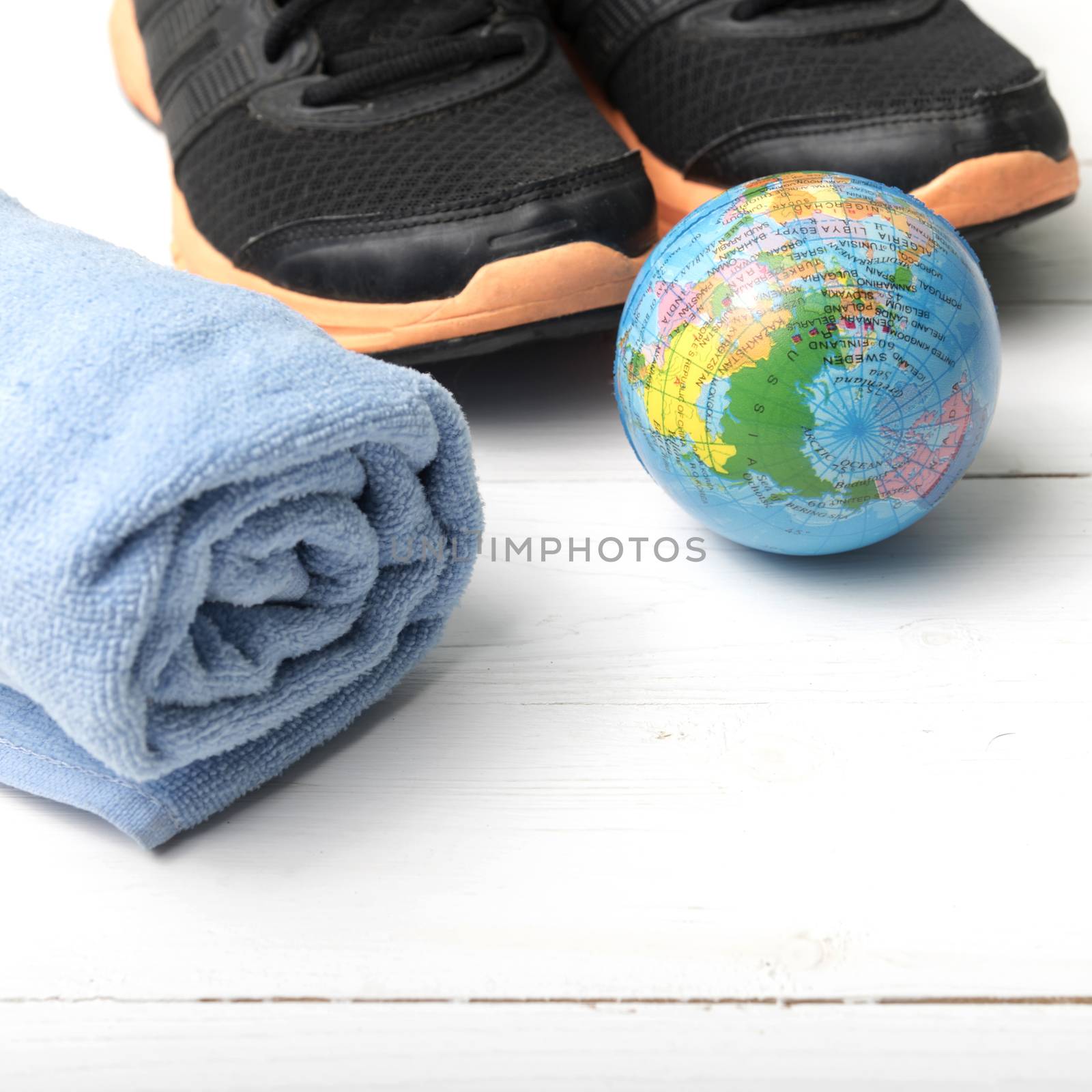 running shoes,towel and earth ball on white wood table concept world healthy