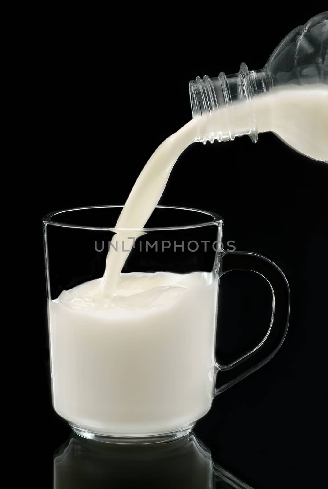 Milk poured from, on black backgraund. Russia