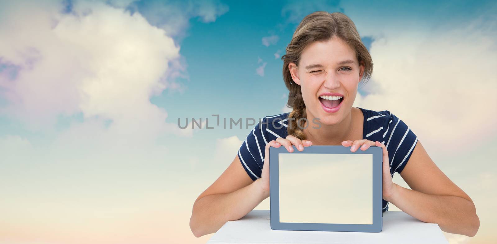 Woman showing tablet pc  against blue sky with white clouds