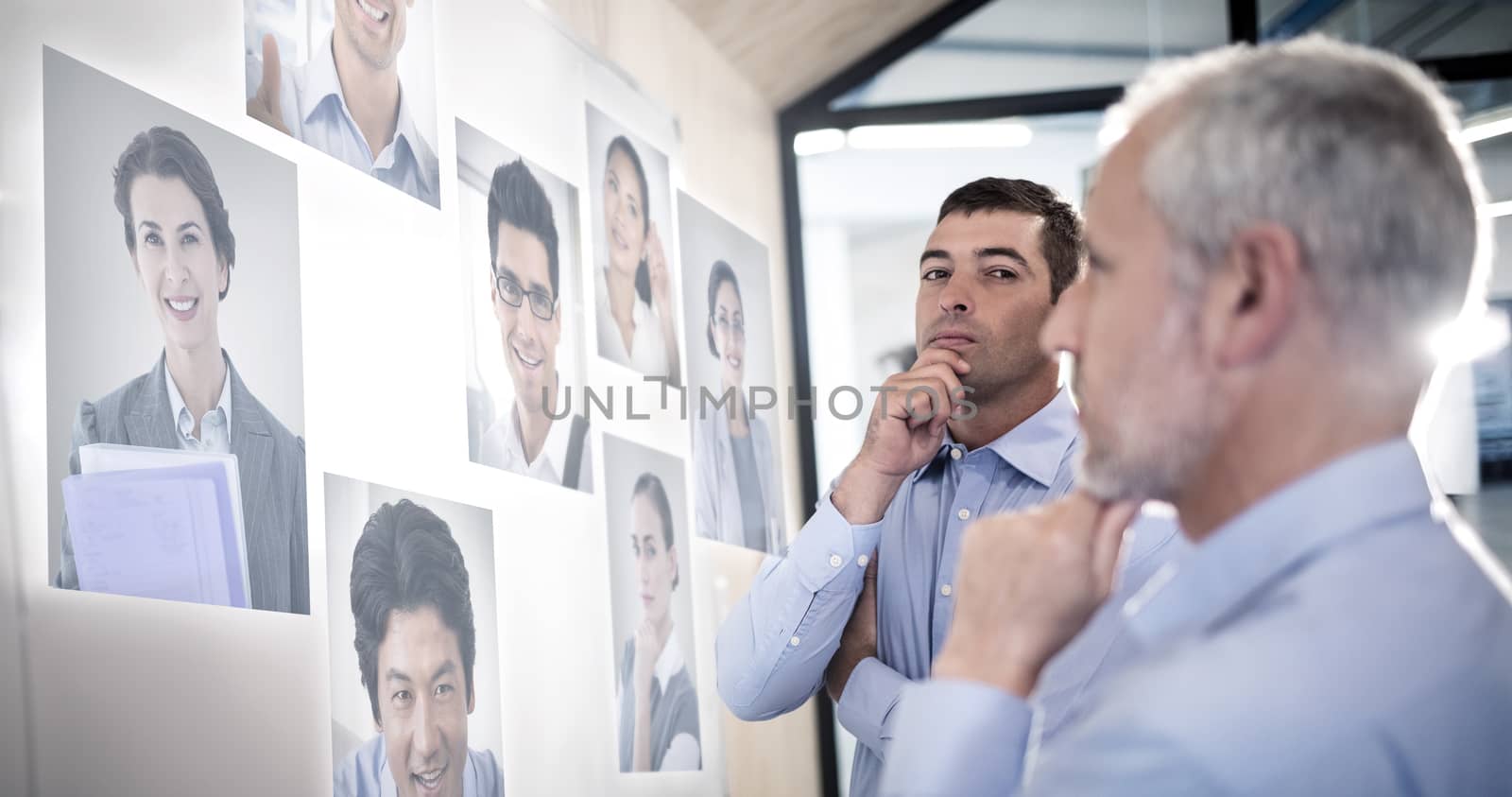 Portrait of business people  against businessman with hand on chin 