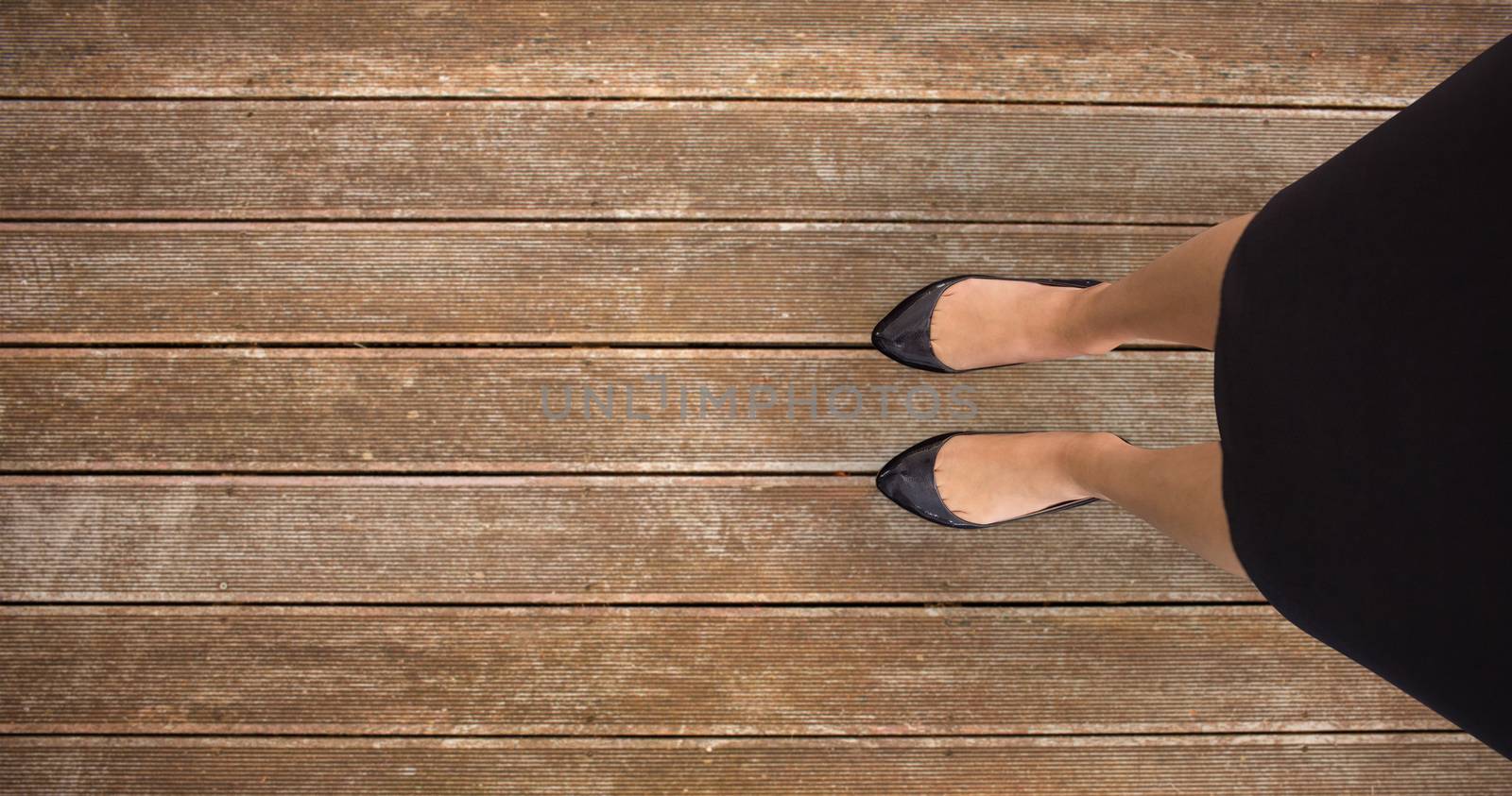 Businesswomans feet against wooden planks background