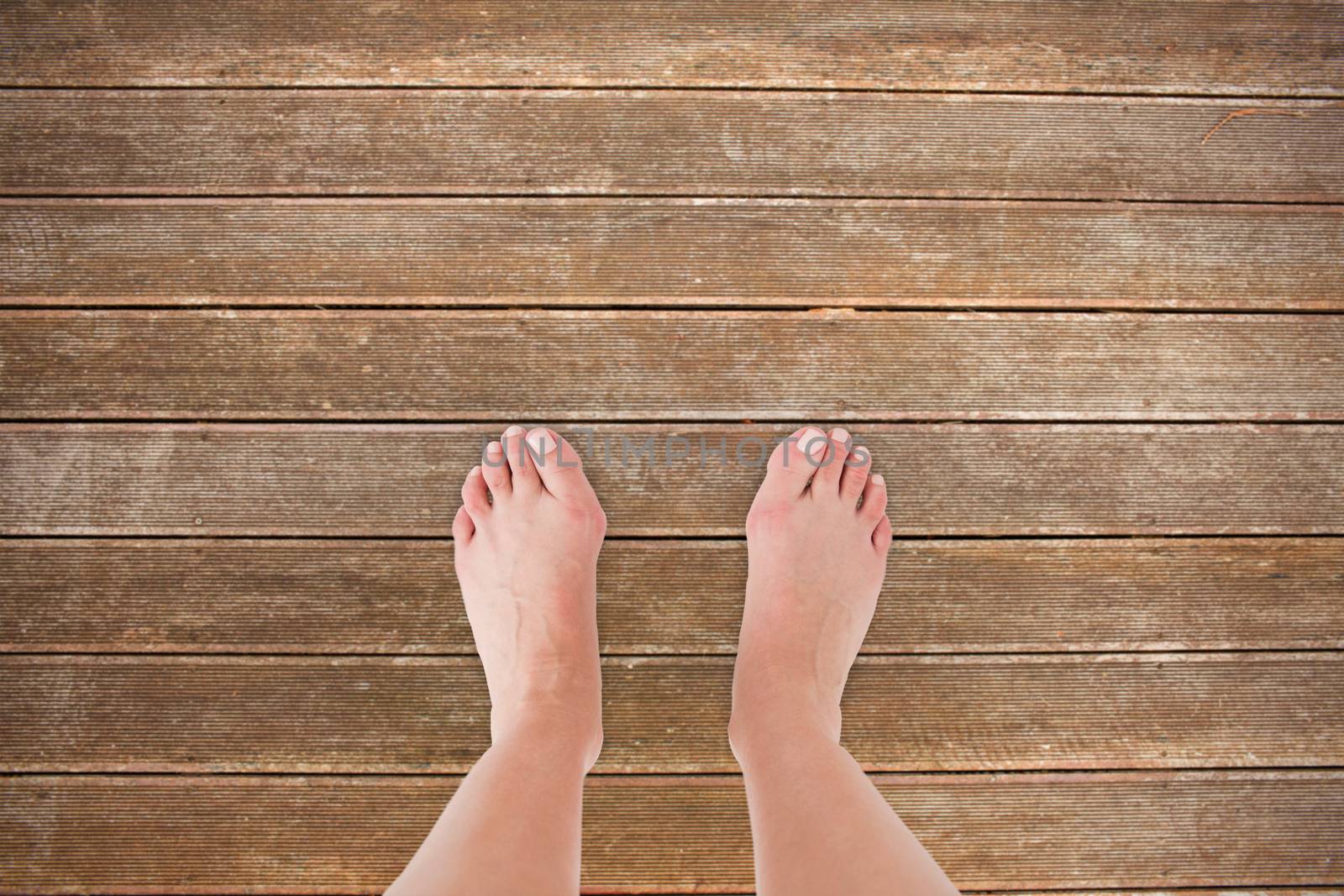 Feet against wooden planks background