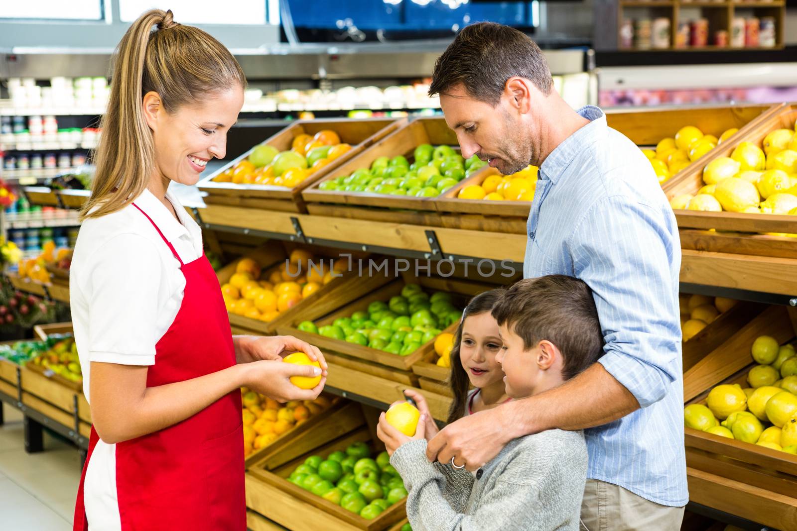 Happy family discussing with worker in grocery store 