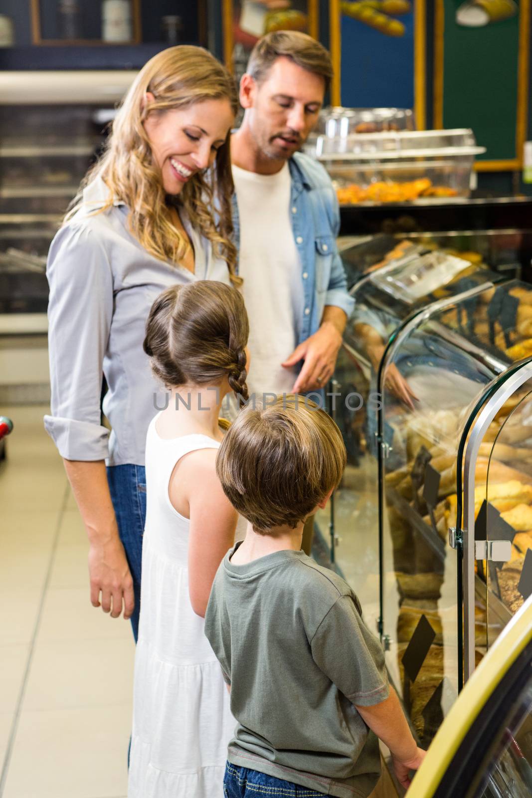 Happy family looking at bread in grocery store 