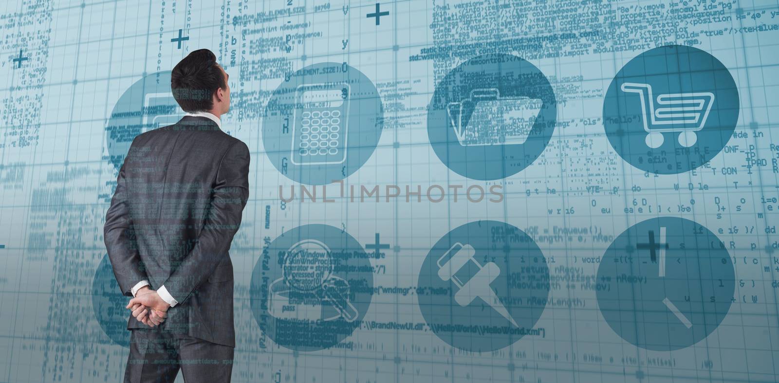 Businessman in grey suit looking against blue matrix and codes