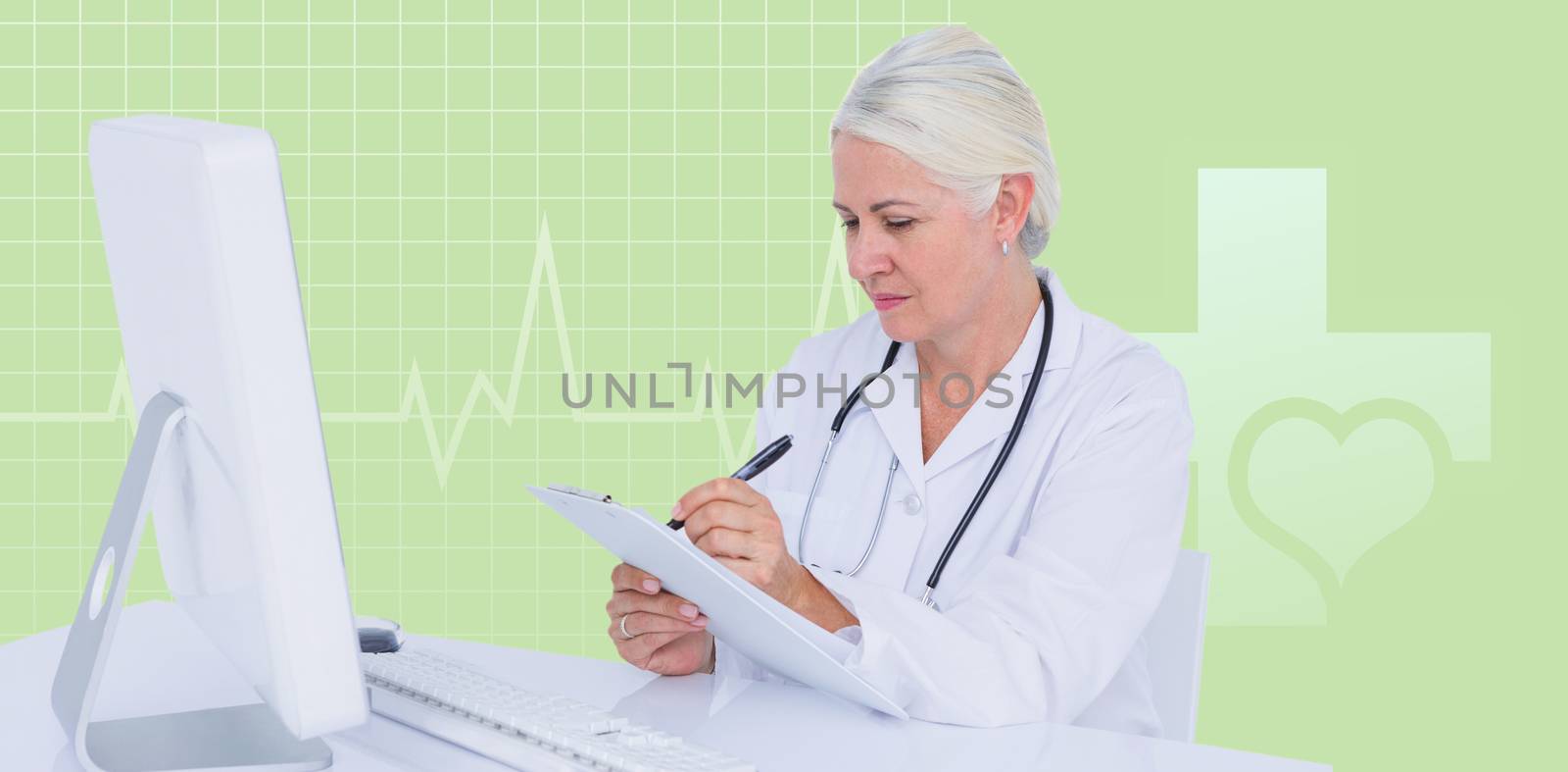 Female doctor writing on clipboard while sitting at desk against green background