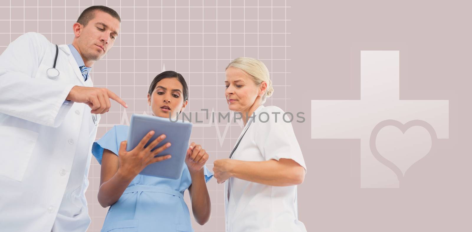 Doctors looking together at tablet against green background
