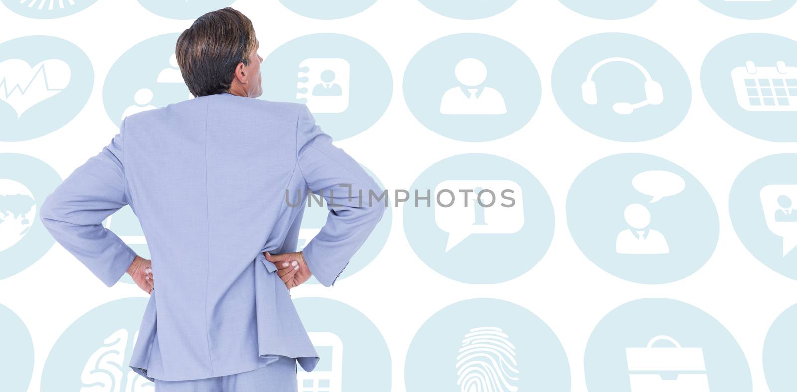  Serious businessman with hands on hips against multiple blue icons 