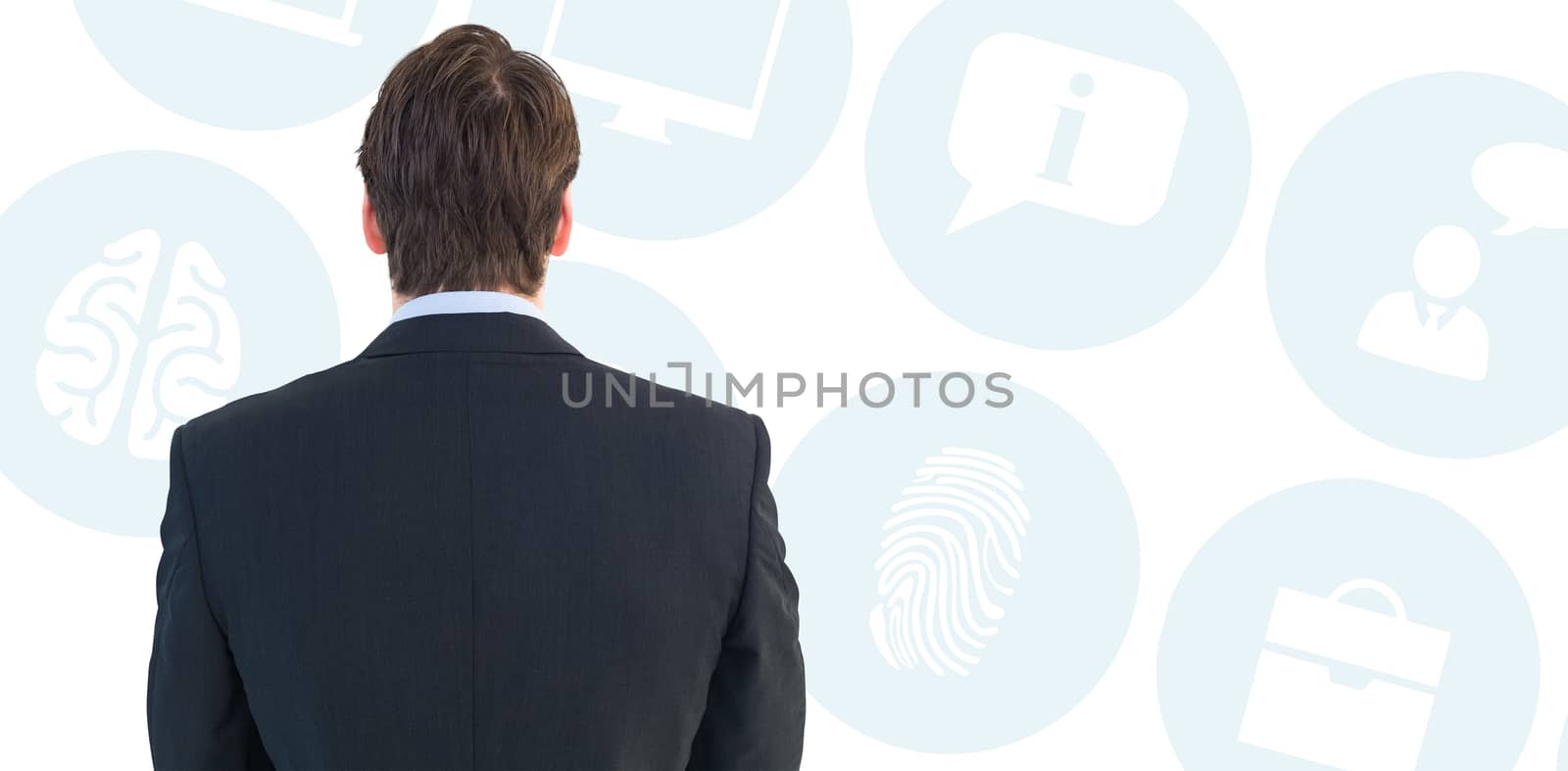 Rear view of businessman standing against multiple blue icons 